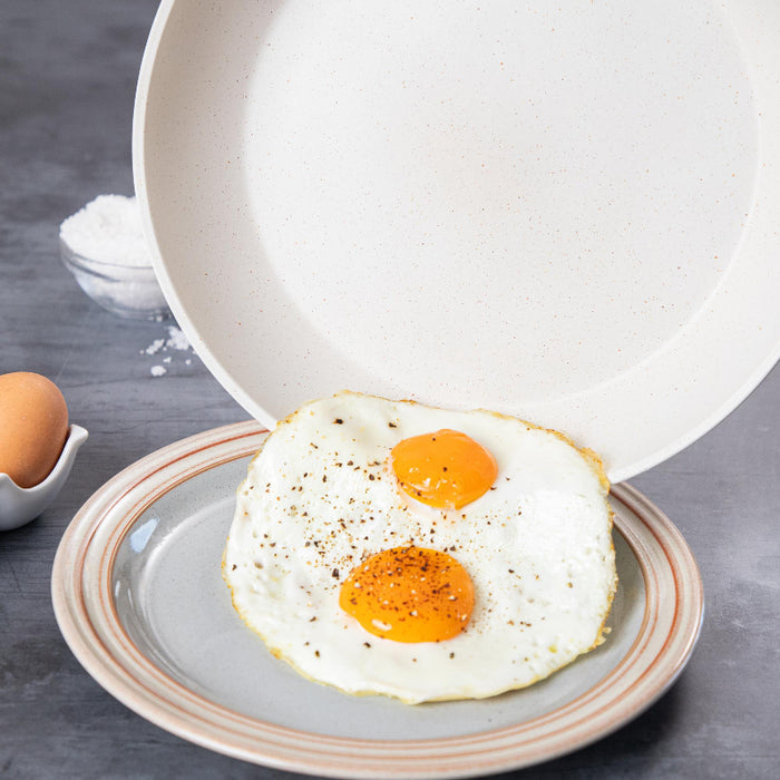 Nuovva 15 piece cream granite cookware set including frying pans with easy transfer and non-stick ceramic coating.