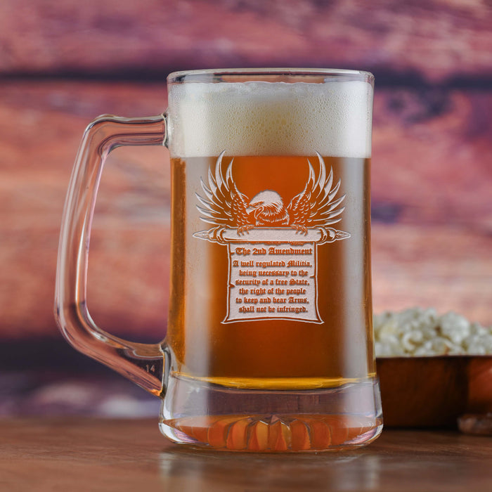 Glass beer mug filled with beer, sand-carved with an eagle perched on a scroll bearing the full text of the Second Amendment.