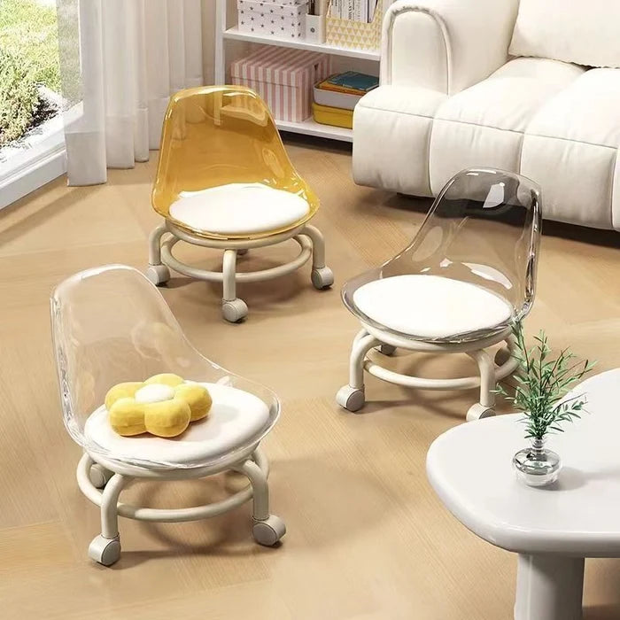 Three acrylic swivel chairs in Golden, clear, and yellow with white cushions and bases are on a rug.