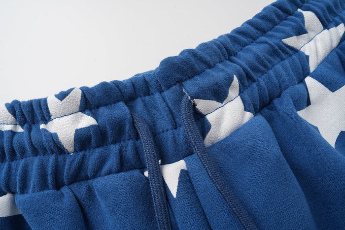 Close-up of blue sweatpants waistband, drawstring, and star print