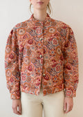 A woman wearing a button front cotton jacket in multicolor kaleidoscope print.