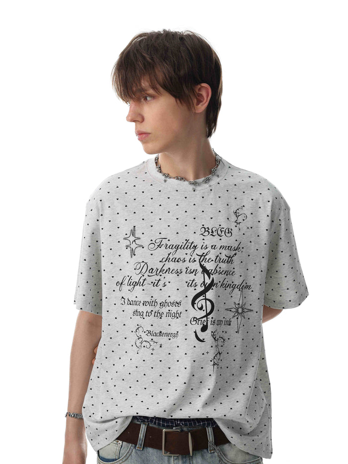 Relaxed gray streetwear tee with micro heart print and gothic script graphic on the chest, worn by a model