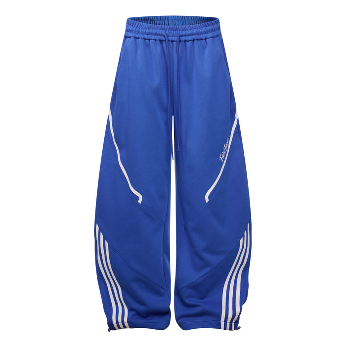 Royal blue wide leg track pants with white curved side stripes and striped lower leg panels