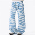 Men's baggy wide-leg jeans in sky blue zebra camouflage print with pleated waistband, front view