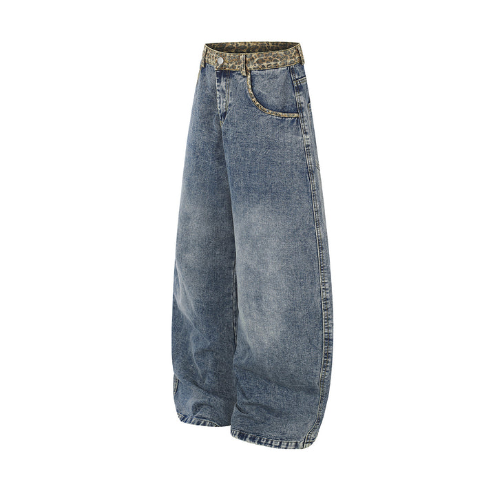 Angled side view of light blue barrel-fit jeans showing the wide leg, side seam, and leopard-print waistband