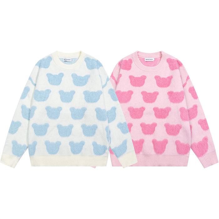 Two bear-pattern crewneck knit sweaters shown from the front in cream with blue motifs and pink with darker pink motifs