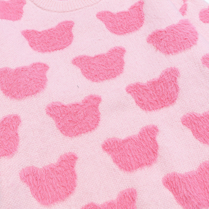 Close-up of the pink knit fabric showing raised fuzzy bear motifs arranged across the sweater