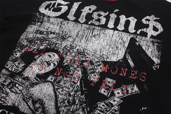 Close-up of the shirt graphic with distressed white lettering, red text, and a black-and-white money collage