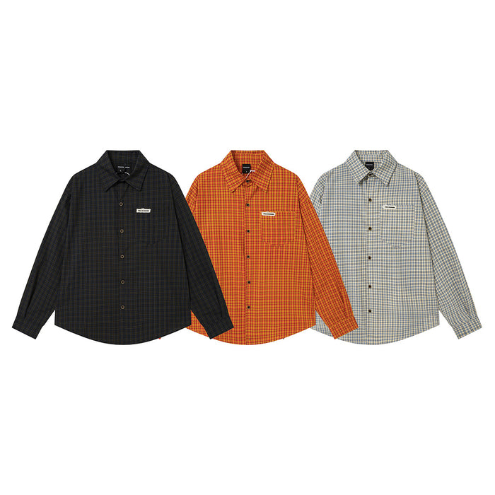 Three long-sleeve plaid button-up shirts in black, orange, and light blue arranged front-facing