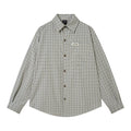 Relaxed-fit long-sleeve blue plaid flannel shirt with chest pocket and woven logo badge, laid flat on white background