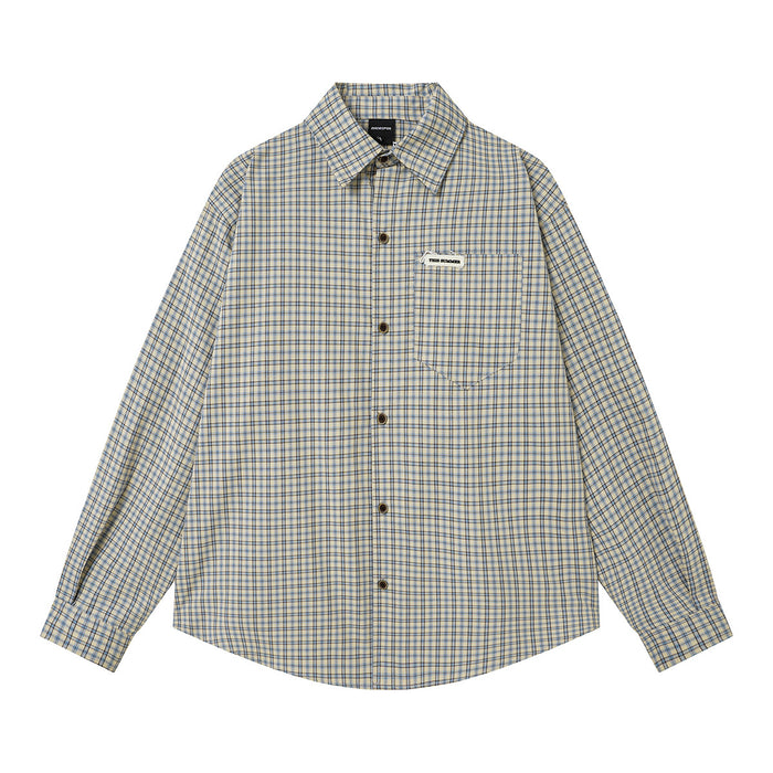 Relaxed-fit long-sleeve blue plaid flannel shirt with chest pocket and woven logo badge, laid flat on white background