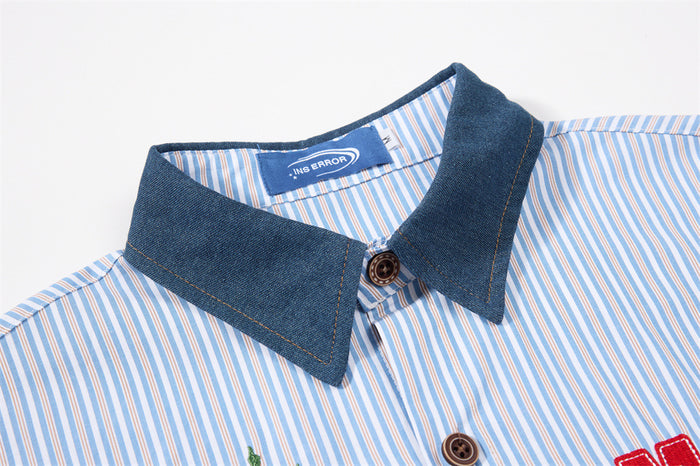 Close-up of the shirt’s dark denim collar, striped fabric, top button, and sewn brand label
