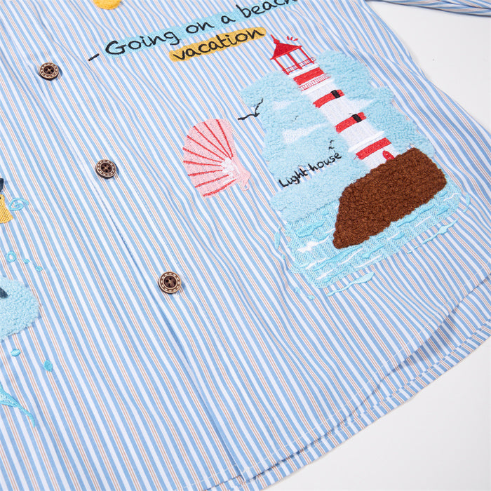 Close-up of beach embroidery on the striped shirt, featuring a red-and-white lighthouse, shell, and beach text