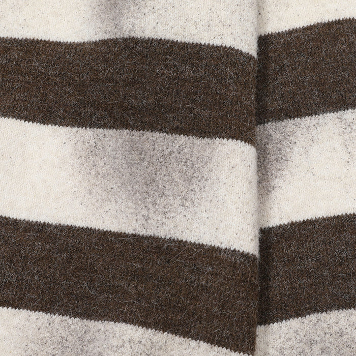 Close-up of brown and cream horizontal knit stripes showing the fuzzy sweater texture and side seam