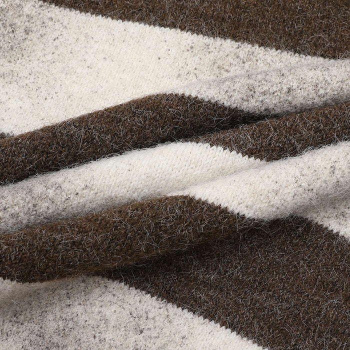 Close-up of folded brown and cream striped sweater fabric showing the soft fuzzy knit texture