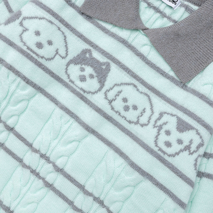 Close-up of four cartoon dog faces knitted across the mint sweater between gray stripes