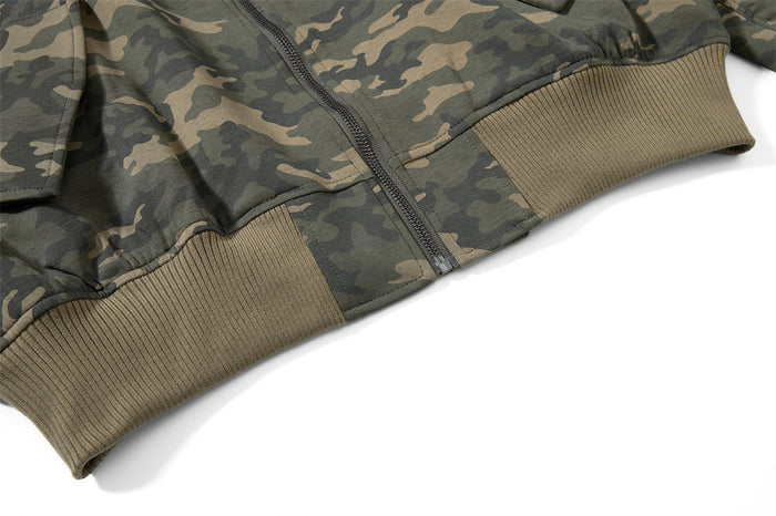Close-up of the camouflage bomber jacket front zipper and textured ribbed waistband