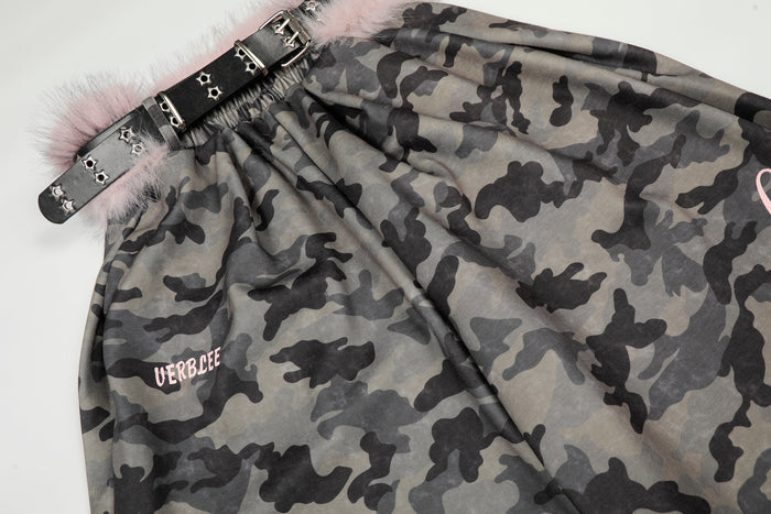 Close-up of studded black belt and gathered camo waistband with pink faux fur trim