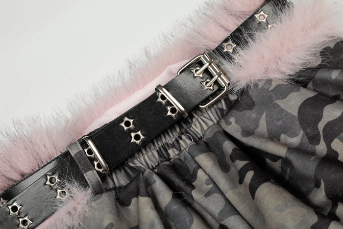 Close-up of belt buckle and stud details on the pink faux fur trimmed waistband