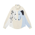 Front view of the cream and light blue button-down shirt with large black-and-white cartoon dog graphics
