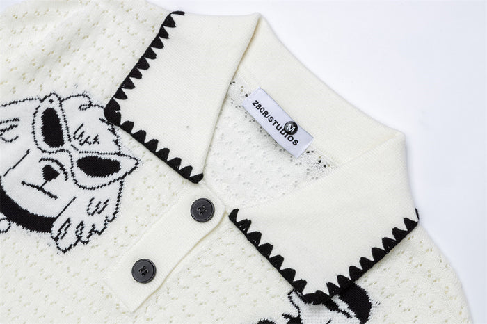 Close-up of the cream sweater's polo collar with black zigzag trim, buttons, and textured knit