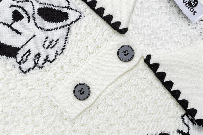 Close-up of two dark buttons, black collar trim, and the cream sweater's raised knit texture