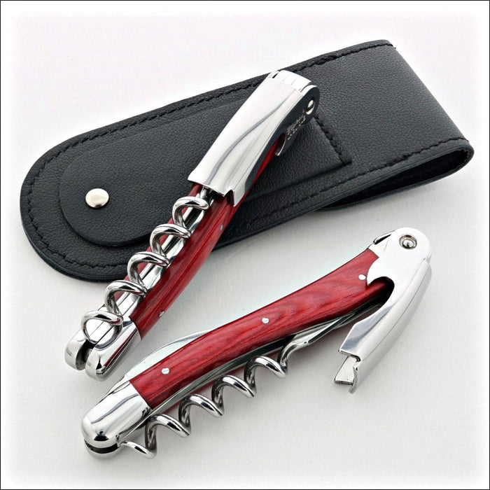 Chateau Laguiole Classic Red Stamina Corkscrew, top-down view of two corkscrews with red wood handles and polished stainless steel, one with a black leather pouch. Handcrafted details, 100% Made in France.