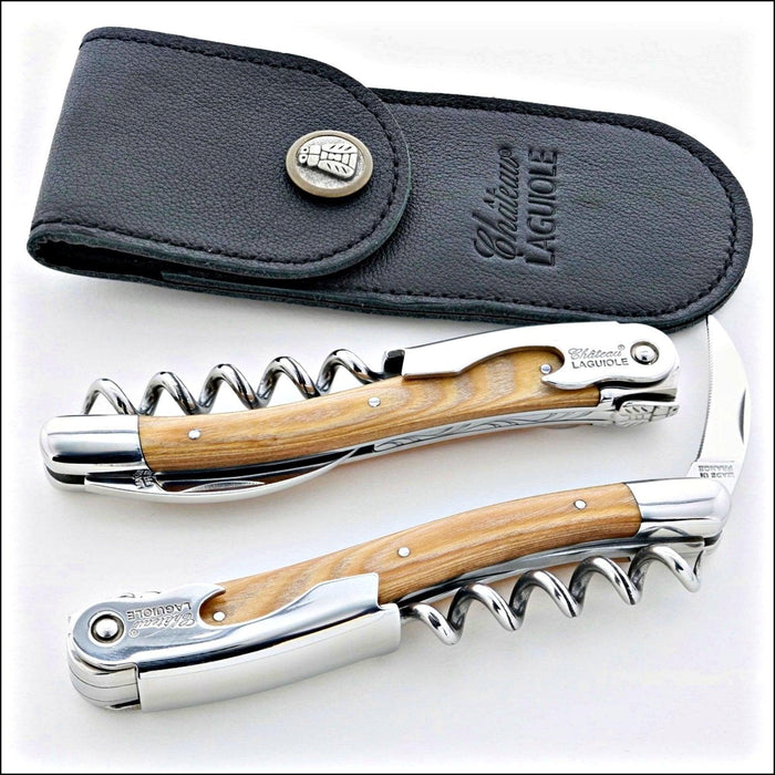 Chateau Laguiole Classic Stamina Corkscrew, top-down view of two corkscrews with light wood handles and a black leather pouch. Handcrafted details, 100% Made in France.