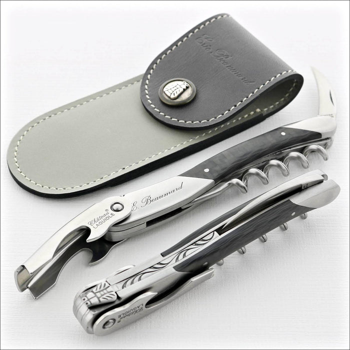 Chateau Laguiole Eric Beaumard Corkscrew, top-down view of two corkscrews and a grey leather sheath. Handcrafted details, 100% Made in France.