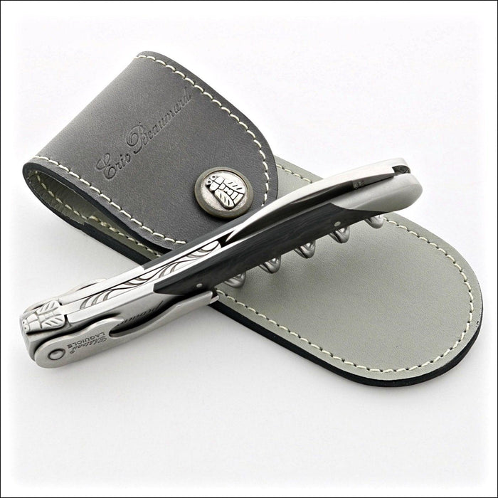 Chateau Laguiole Eric Beaumard Corkscrew, side view. Dark wood handle, stainless steel, gray leather sheath. Handcrafted details, 100% Made in France.