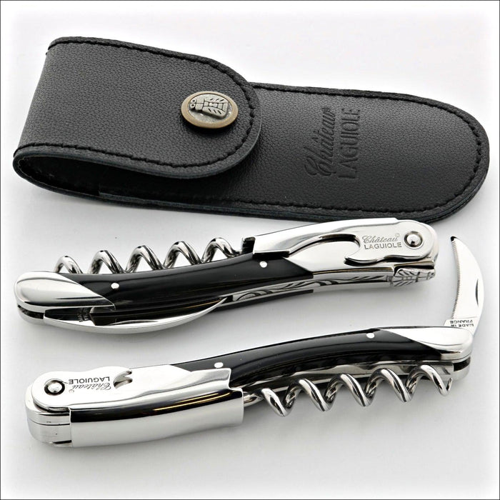 Chateau Laguiole Grand Cru Dark Horn Tip Corkscrew, top-down view of two corkscrews with black horn handles and polished steel, alongside a black leather sheath. Handcrafted details, 100% Made in France.