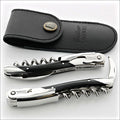 Chateau Laguiole Grand Cru Dark Horn Tip Corkscrew, top-down view of two corkscrews with black horn handles and polished steel, alongside a black leather sheath. Handcrafted details, 100% Made in France.