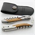 Chateau Laguiole Grand Cru Olive Wood Corkscrew, top-down view of two corkscrews and black leather sheath. Handcrafted details, 100% Made in France.