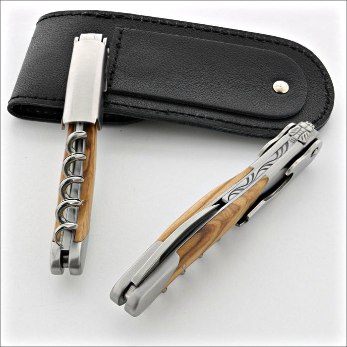 Chateau Laguiole Grand Cru Olive Wood Corkscrew, top-down view of two corkscrews and black leather case. Handcrafted details, 100% Made in France.