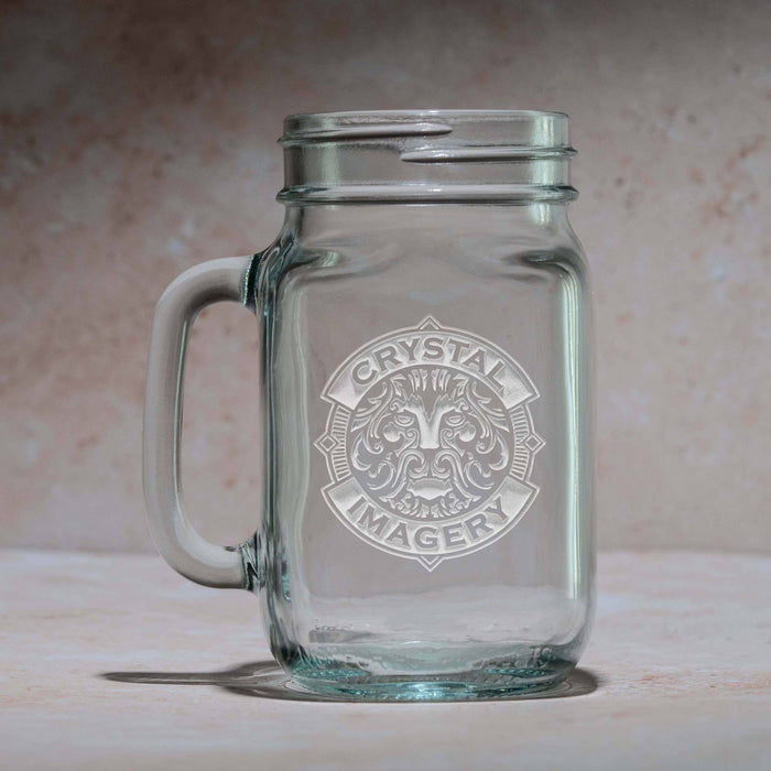 Mason jar mug with a handle, sand-carved with a sample Crystal Imagery crest where your logo would go, shown against a stone background.