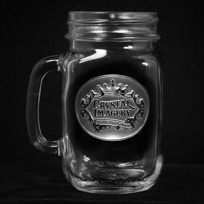 Mason jar mug with a handle, sand-carved with an older Crystal Imagery 'Distinctive Barware' crown crest, on a black background.
