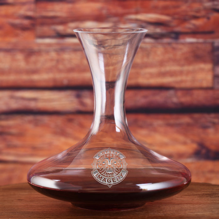 Round-bottomed aerating wine decanter with a flared neck, filled with red wine, deep-carved with a sample Crystal Imagery crest where your logo would go.