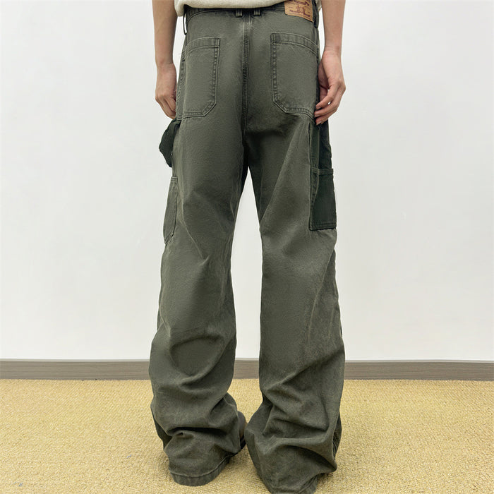 Back view of olive green wide-leg carpenter pants worn on a model, showing patch pockets and side utility pockets