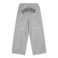 Gray wide-leg sweatpants with graphic text, red stars, and long drawstrings, front view