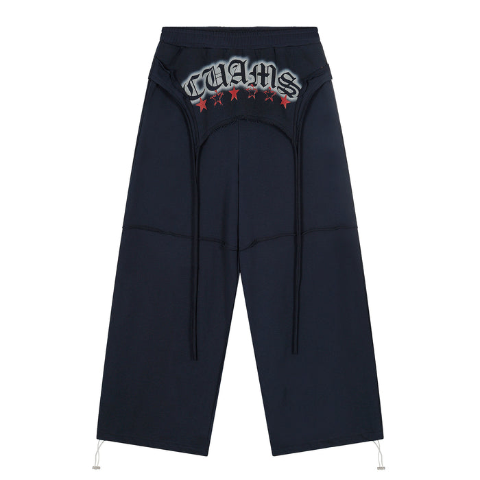 Black wide-leg sweatpants with graphic text and red stars, front view