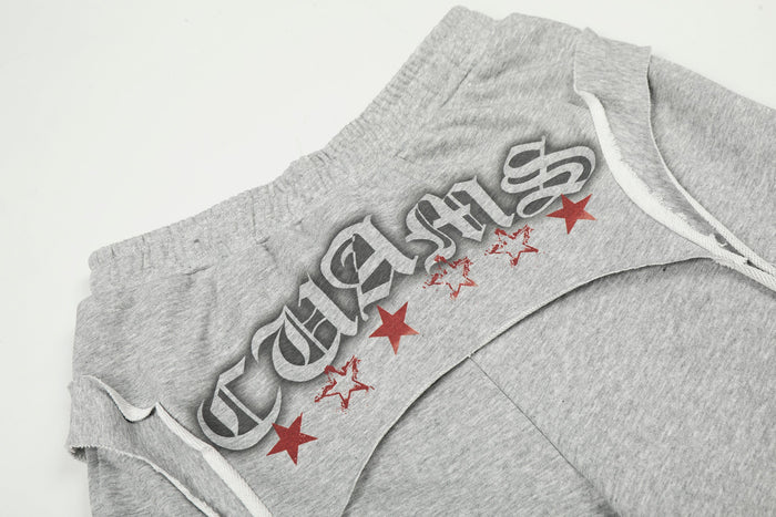 Close-up of gray sweatpants waistband with graphic text and red star print