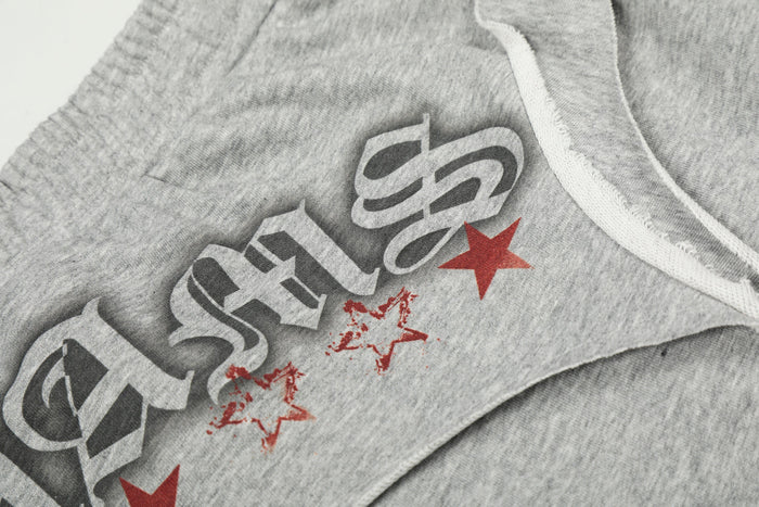 Close-up of gray sweatpants graphic print with text and red star accents
