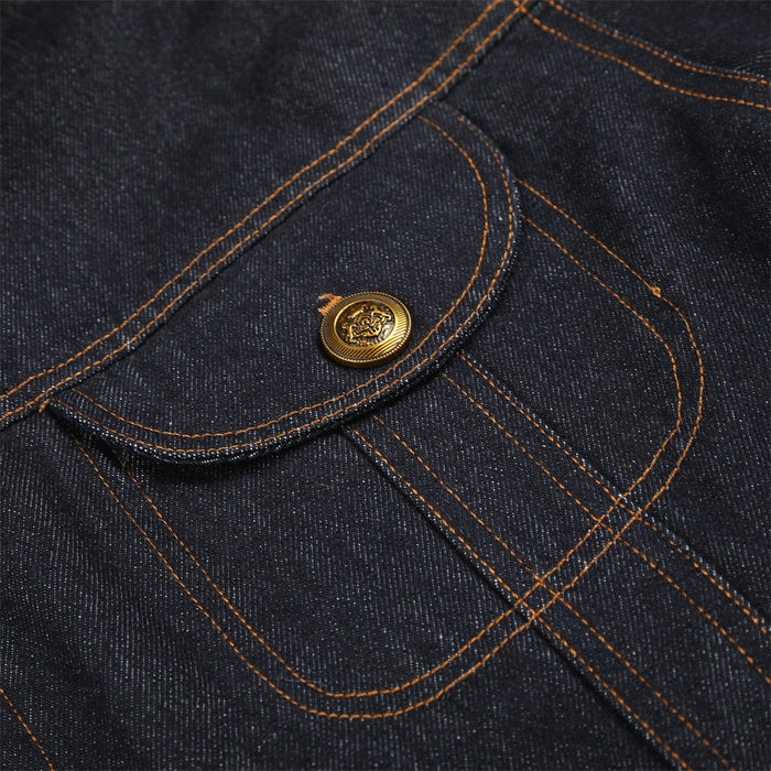 Close-up of a denim chest pocket with curved flap, orange stitching, and ornate gold-tone button
