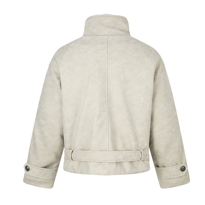 Back view of the cream jacket showing its raised collar, center seam, sleeves, and waist belt