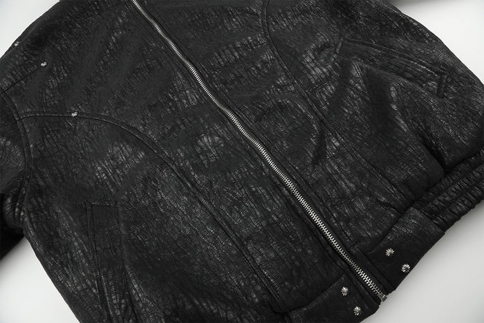 Close-up of the black textured bomber jacket front with zipper, padded body, and ribbed hem