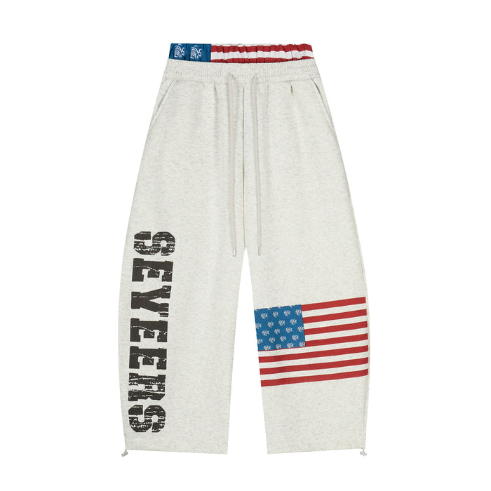 Front view of heather gray wide-leg sweatpants with flag print and black graphic leg text