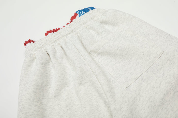 Close-up of heather gray sweatpants back pocket and elastic waistband stitching