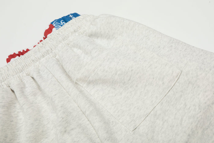 Close-up of heather gray sweatpants back pocket seam and elastic waistband
