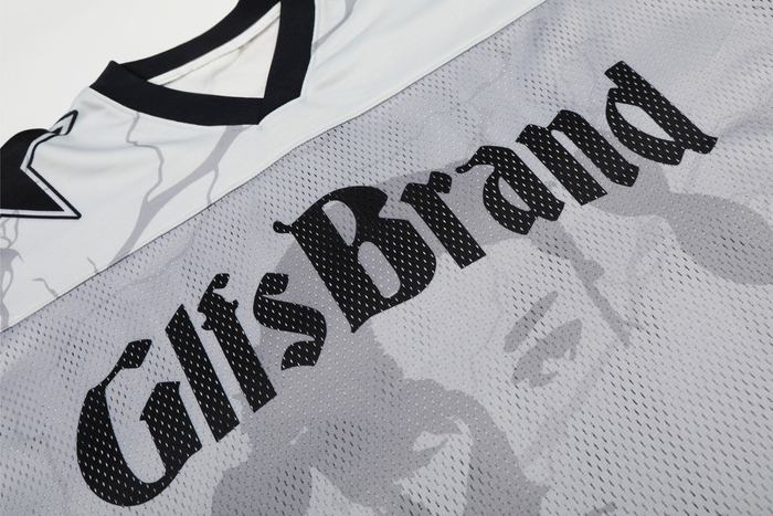 Close-up of a white mesh football jersey with black trim and bold GlfsBrand lettering across the chest