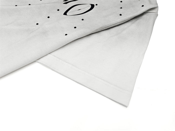 Close-up of a washed white oversized T-shirt with black gothic logo print and distressed streetwear style.